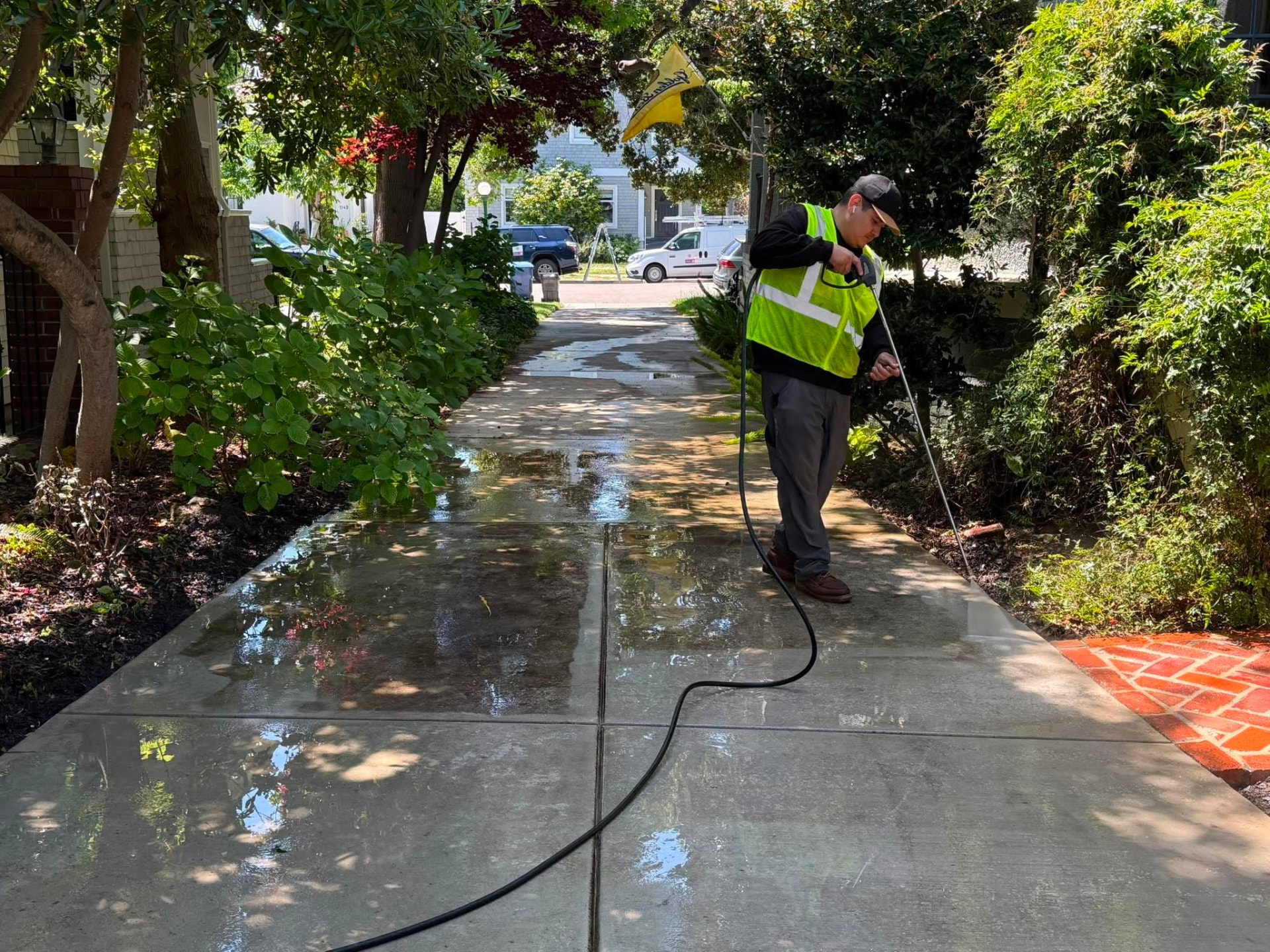 PQ Precision Panes technician pressure washing a residential walkway