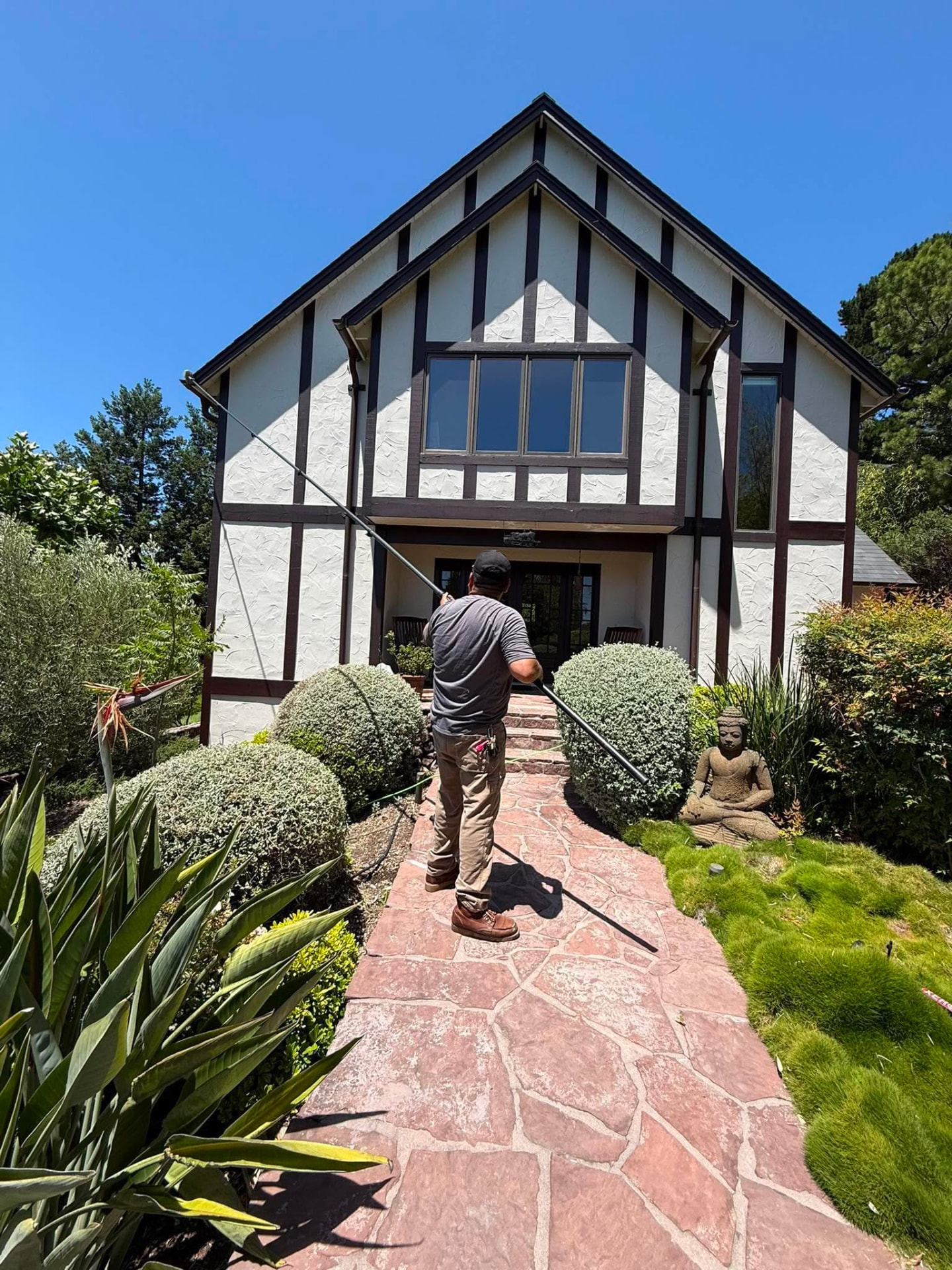 PQ Precision Panes crew member cleaning exterior windows with a water-fed pole